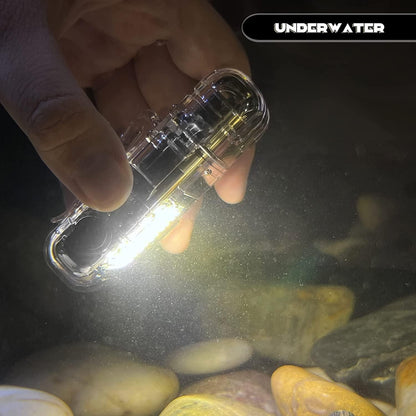 Hand holding a clear underwater light device with 'Underwater' text above, illuminating rocks and water.