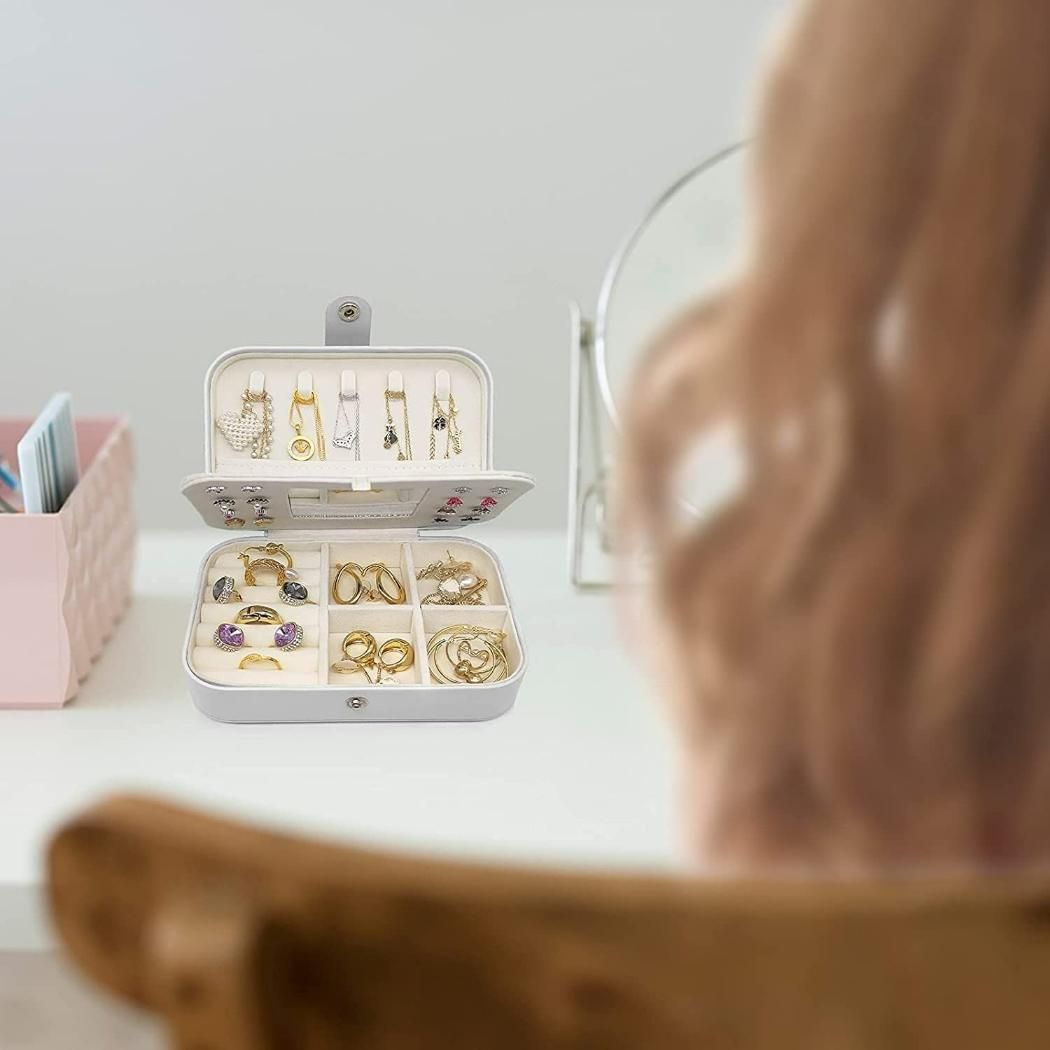 Jewelry organizer with earrings on a table, blurred person in foreground